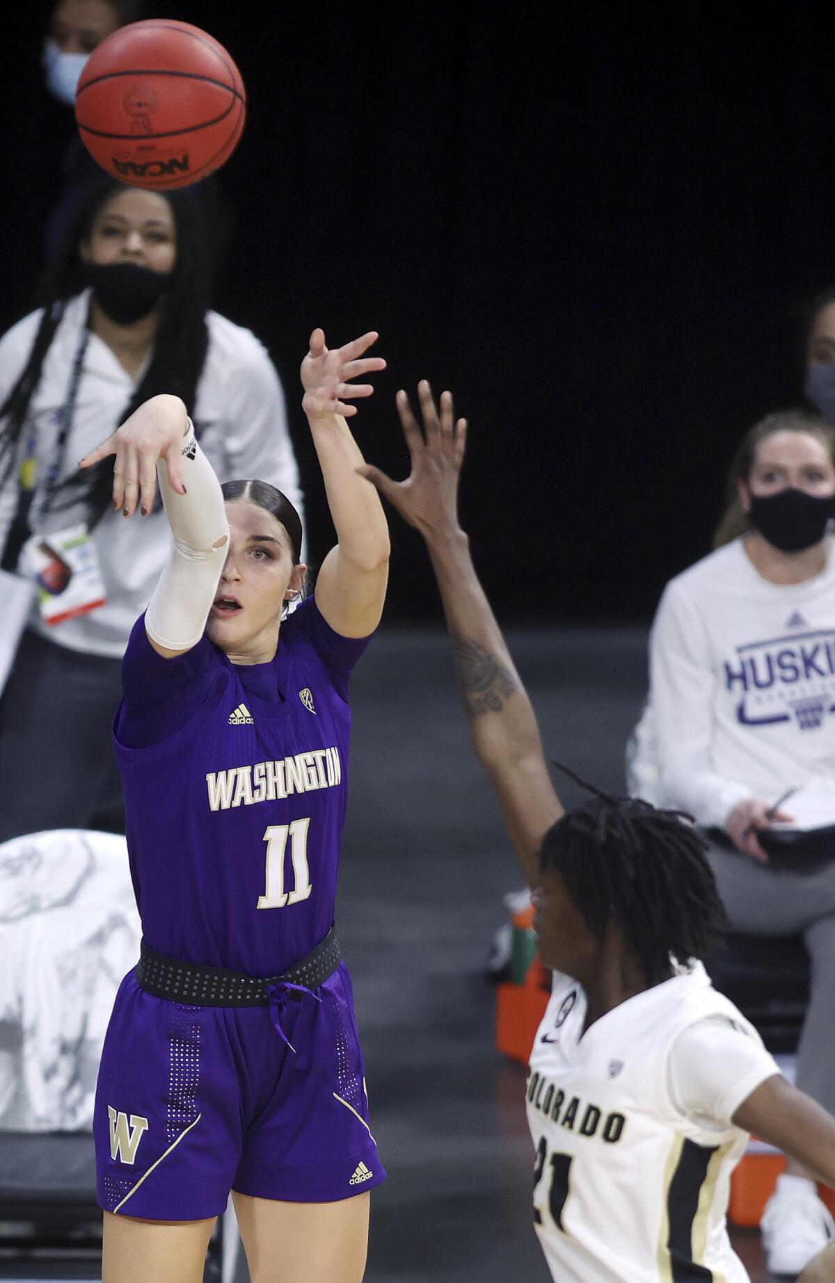 Washington forward Haley Van Dyke (11) shoots as Colorado guard Mya Hollingshed (21) defends during an NCAA college basketball game in the first round of the Pac-12 women's tournament Wednesday, March 3, 2021, in Las Vegas. (AP Photo/Isaac Brekken)
