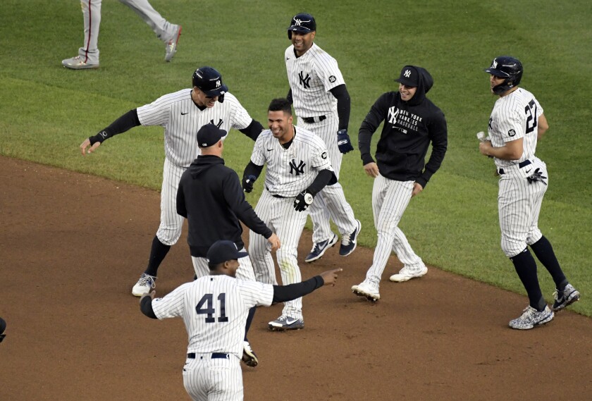 New York Yankees' Gleyber Torres, center, is congratulated by teammates after he drove in the winning run in the 11th inning of a baseball game to defeat the Washington Nationals 4-3, Saturday, May 8, 2021, at Yankee Stadium in New York. (AP Photo/Bill Kostroun)
