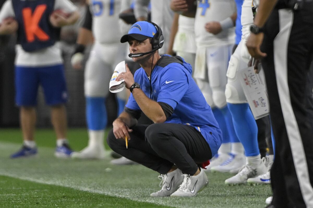 Los Angeles Chargers head coach Brandon Staley kneels on the sideline during the second half of an NFL football game against the Las Vegas Raiders, Sunday, Jan. 9, 2022, in Las Vegas. (AP Photo/David Becker)