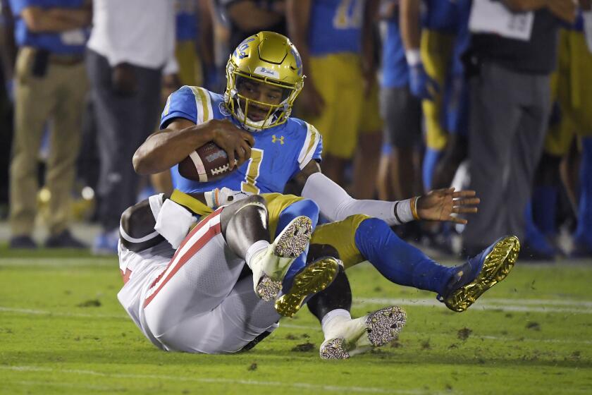 UCLA quarterback Dorian Thompson-Robinson, top, is sacked by Oklahoma linebacker Brian Asamoah during the second half of an NCAA college football game Saturday, Sept. 14, 2019, in Pasadena, Calif. (AP Photo/Mark J. Terrill)