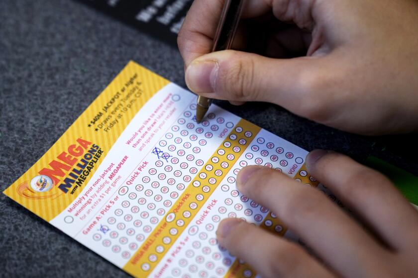 A customer fills out a Mega Millions lottery ticket at a convenience store Tuesday, Jan. 3, 2023, in Northbrook, Ill. (AP Photo/Nam Y. Huh)