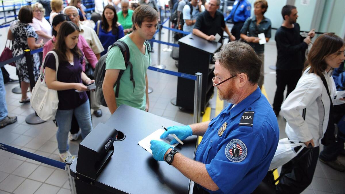 A TSA agent checks an id under a Fraud Fighter machine in Terminal 1 at LAX.