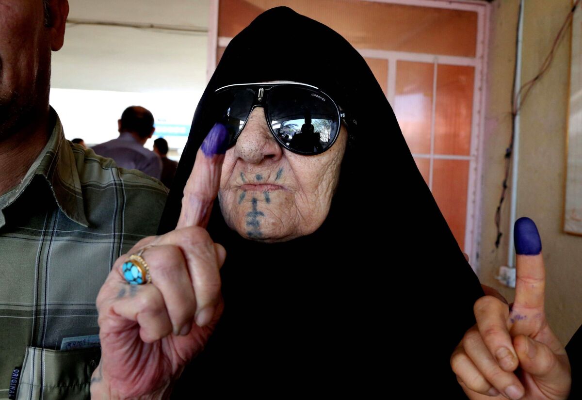An Iraqi woman shows her ink-stained finger after voting at a polling station in Baghdad on Wednesday.