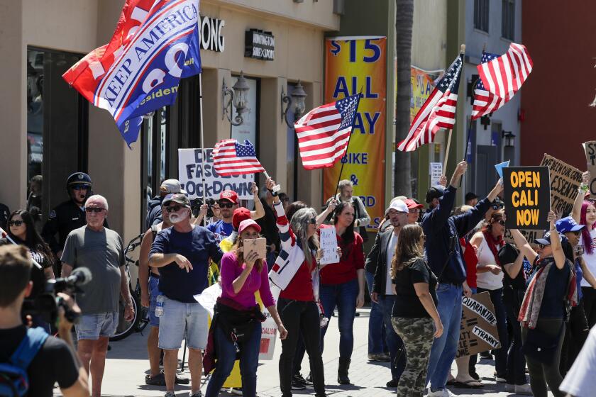 HUNTINGTON BEACH, CA - APRIL 17: A big number of Trump supporters rally on Main Street against business closure due to COVID-19 pandemic. Huntington Beach, CA. (Irfan Khan / Los Angeles Times)