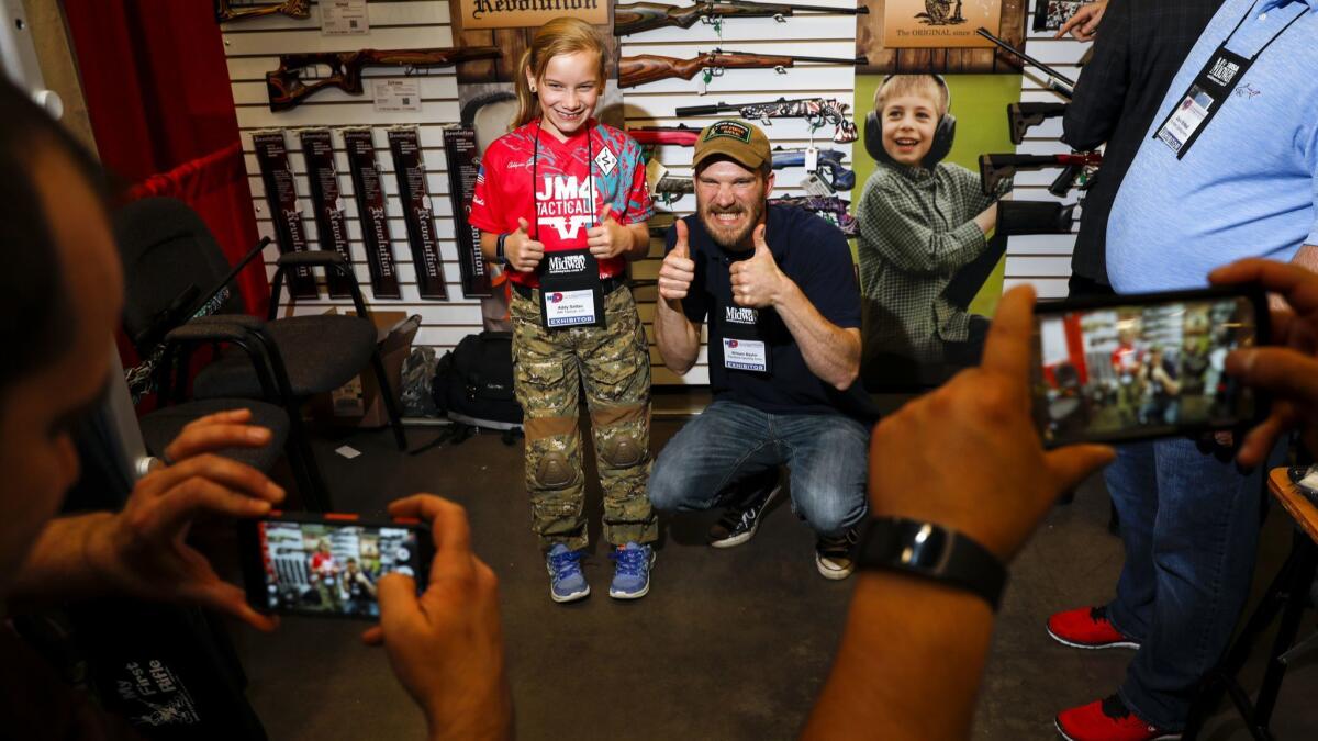 William Baylor, with Keystone Sporting Arms, poses for a photo with NRA celebrity Addyson "Alpha Addy" Soltau in Dallas on May 6.