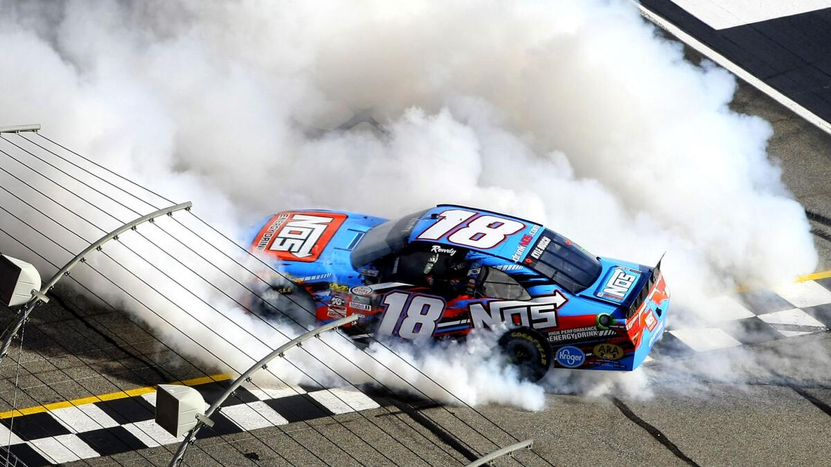 Kyle Busch does a burnout at the finish line while celebrating winning a win Saturday in the NASCAR XFinity Series race at Atlanta Motor Speedway.