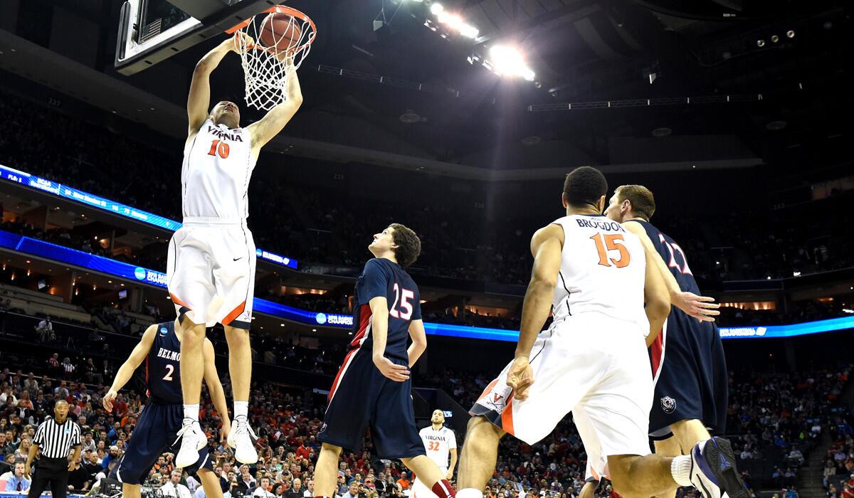 Virginia's Mike Tobey dunks over Belmont players during the second round of the 2015 NCAA Men's Basketball Tournament on Friday.