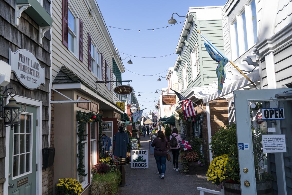 ARCHIVO - Gente pasea en una calle de tiendas en Rehoboth Beach, Delaware, EEUU. 