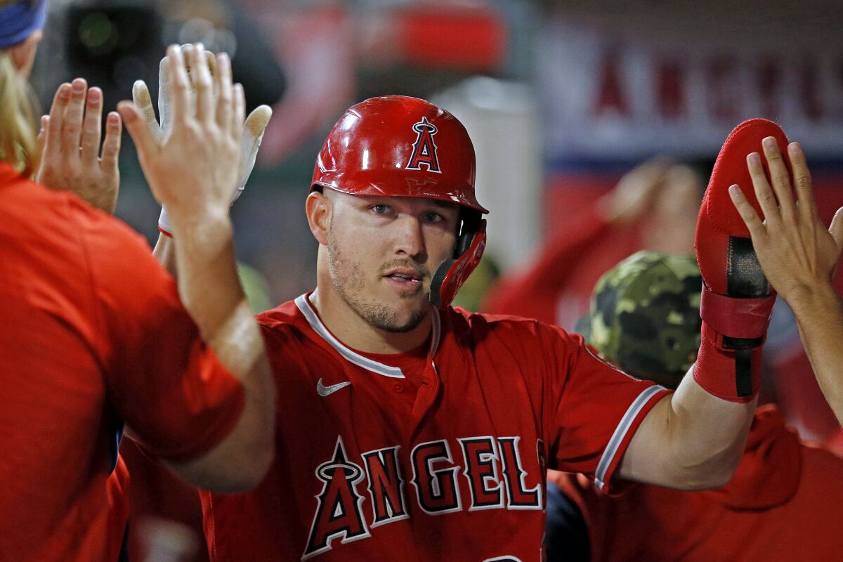 The Angels' Mike Trout is congratulated by teammates after scoring in the sixth inning May 21, 2022.