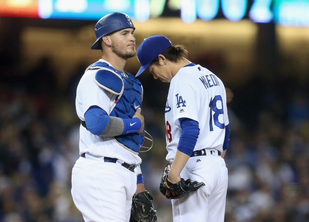 Kenta Maeda and Yasmani Grandal wait as Manager Dave Roberts walks to the mound to relieve Maeda in the seventh inning Thursday.