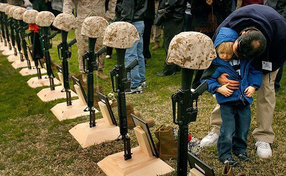 Don Crass comforts his grandson Brenton Throop, 4, during a memorial service for Marine and Navy personnel killed during a recent eight-month deployment. Crass' son, Marine Lance Cpl. Layton Crass, was killed June 14, 2008.