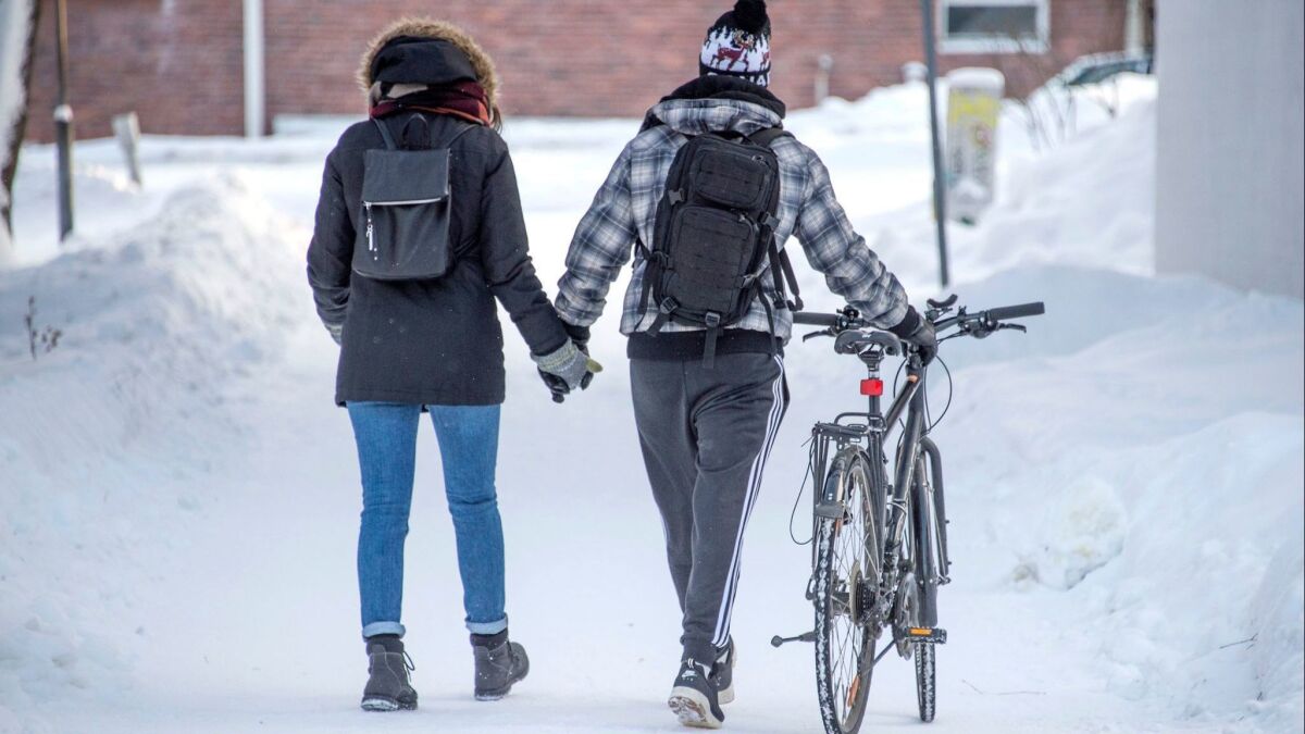 A couple walks on a snow-covered street in Jyvaskyla, Finland, on Jan. 18.
