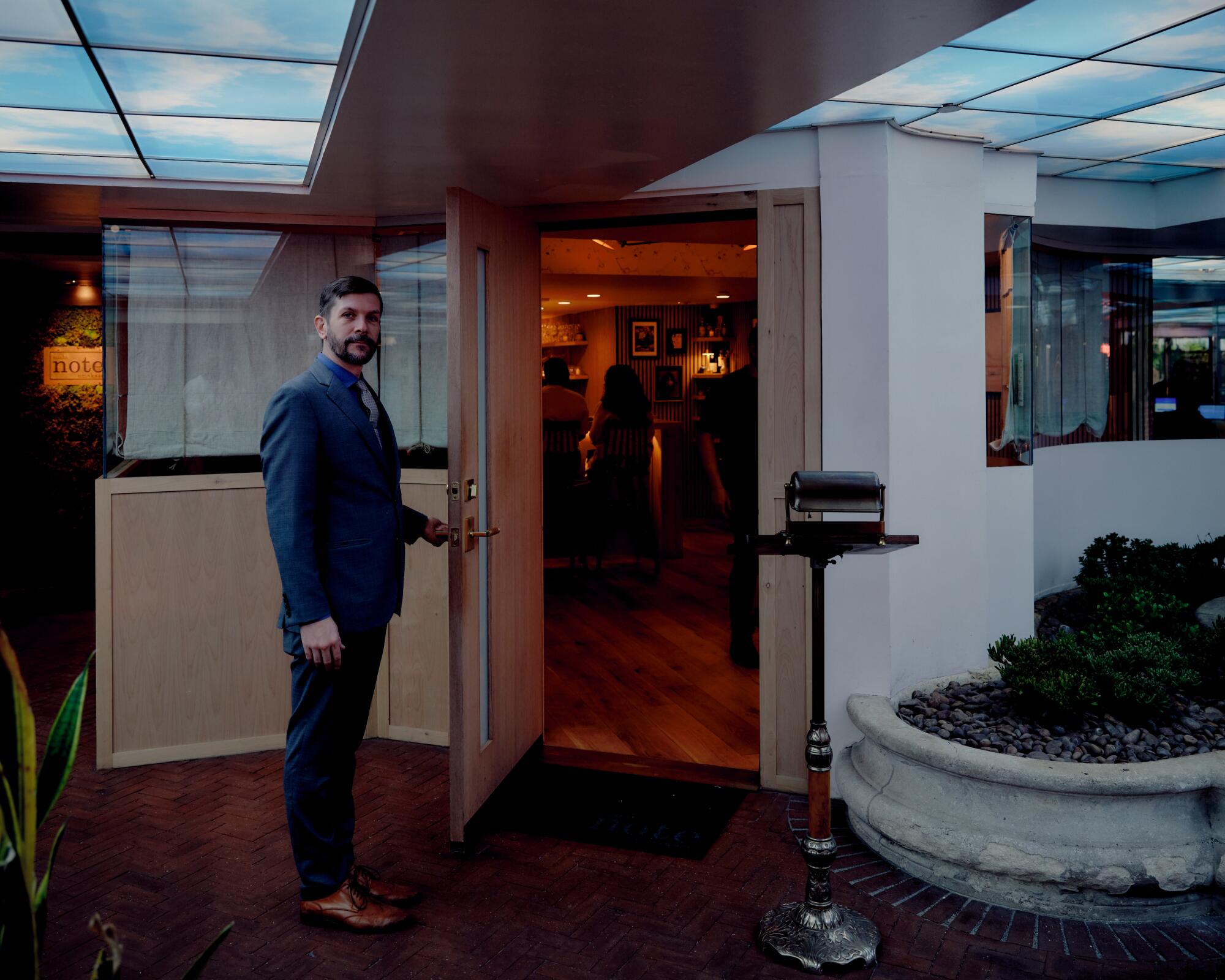 General manager Austin Ferrier opens the door to the compact, subterranean dining room at Sushi Note.