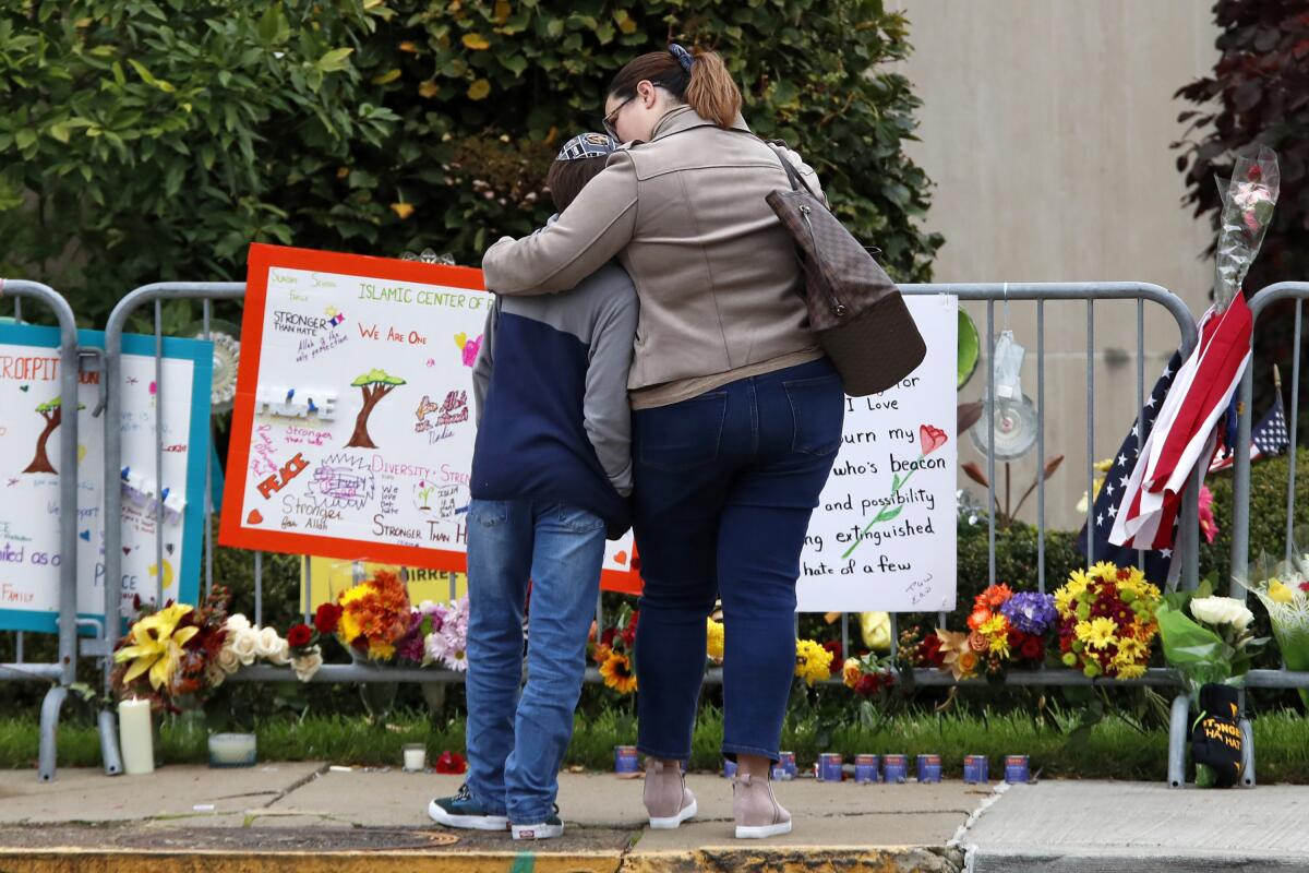 A mother and son visit a memorial at the Tree of Life synagogue in Pittsburgh on Sunday, the first anniversary of a shooting there that killed 11.