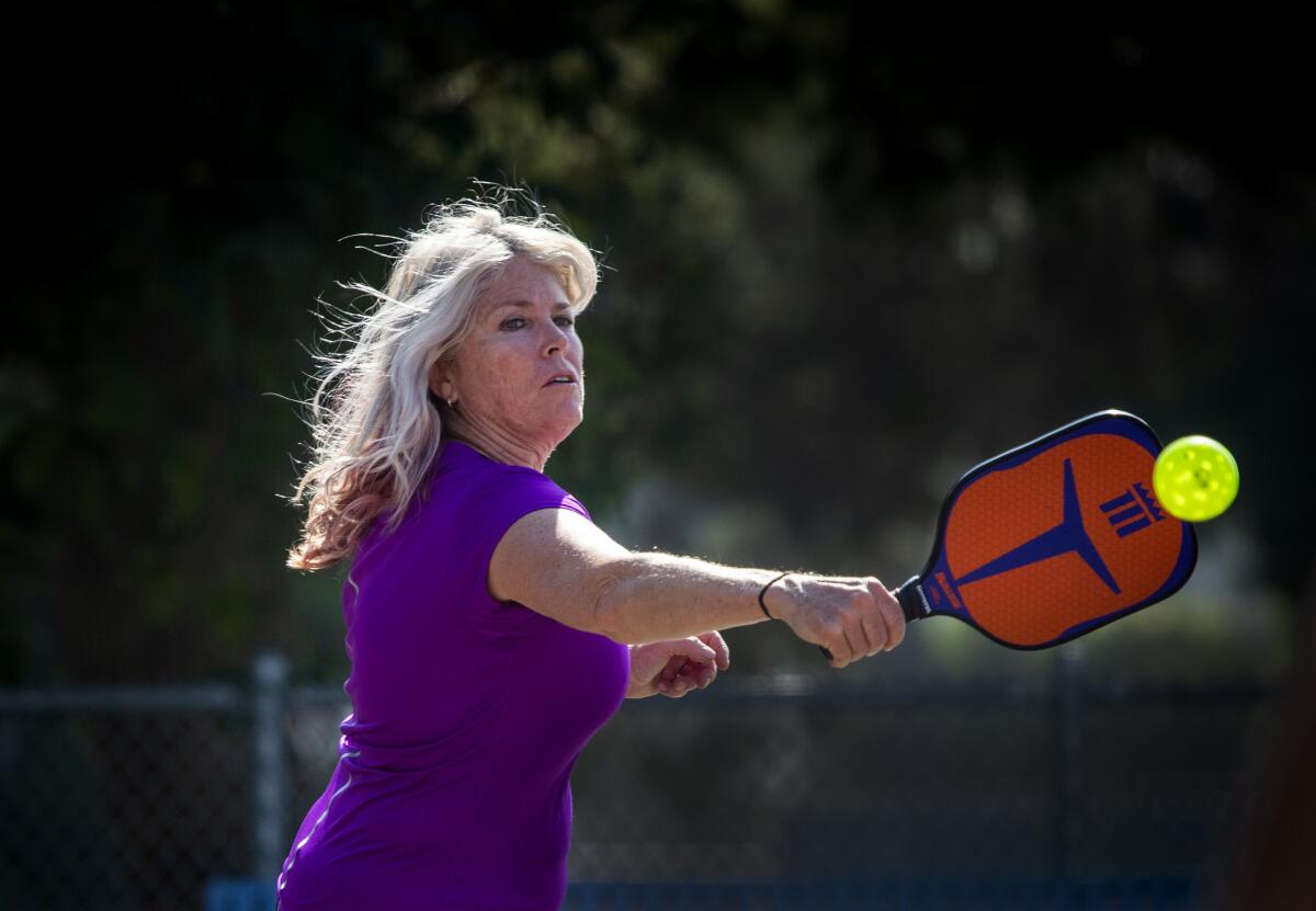 Susan Joyner makes a backhand return while playing pickleball at the Worthy Park courts in Huntington Beach.