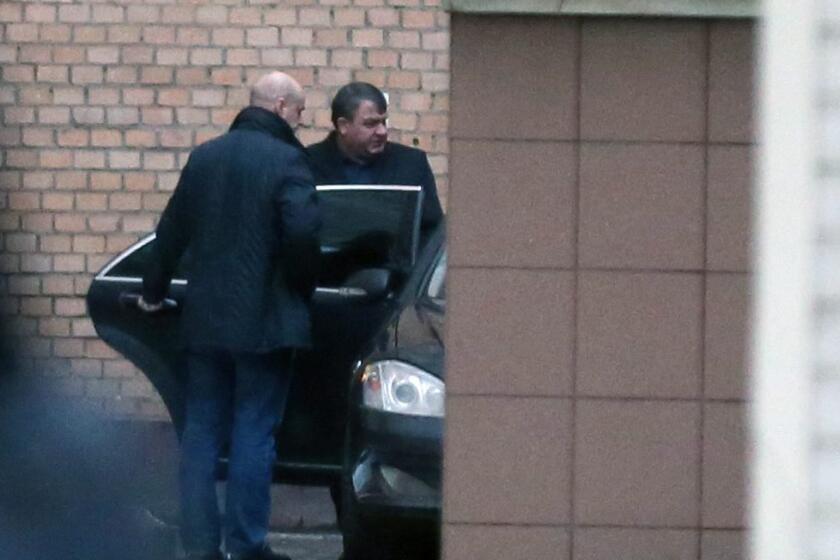 Former Russian Defense Minister Anatoly Serdyukov, right, leaves the Investigative Committee office in Moscow on Friday.
