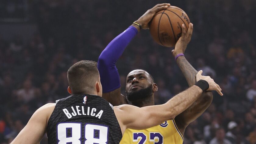 Lakers forward LeBron James, right, is fouled by Sacramento Kings forward Nemanja Bjelica during the second quarter.