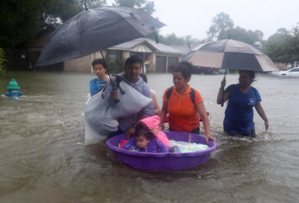 Adults use a kiddie pool to transport children as they evacuate on Monday. (Joe Raedle / Getty Images)