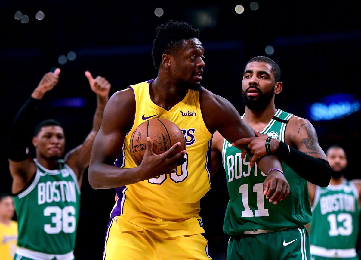 LOS ANGELES, CA - JANUARY 23: Julius Randle #30 of the Los Angeles Lakers reacts as he is tied up by Kyrie Irving #11 of the Boston Celtics for a jump ball during the first half at Staples Center on January 23, 2018 in Los Angeles, California.