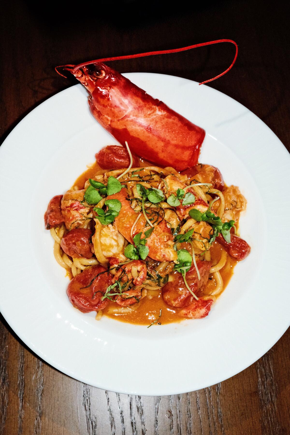 A lobster head perches at the top of a white bowl of lobster-bisque bucatini at West Hollywood restaurant Chez Mia