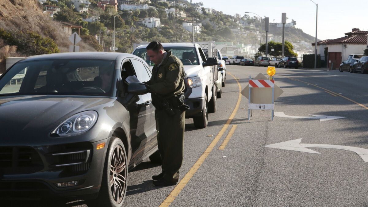 Law enforcement officials check the IDs of residents returning to Malibu. The evacuation order has been lifted for Malibu from Carbon Canyon to Webb Way.