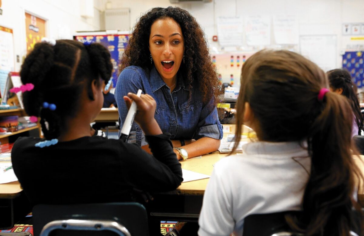 Samantha Pulliam, a first-grade teacher at 24th Street Elementary in Los Angeles, goes over a writing lesson with students. Pulliam, 27, began her teaching career at a charter school because no positions were available in L.A. Unified at the time.