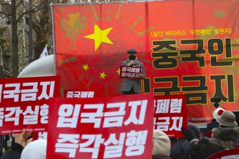 Manifestantes surcoreanos durante una marcha para pedir que se prohíba la entrada de personas chinas en el país, cerca de la sede oficial de la presidencia, la Casa Azul, en Seúl, Corea del Sur.