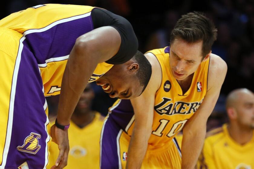 LOS ANGELES, CA, THURSDAY, FEBRUARY 22, 2013 -- FILE - The Lakers' Dwight Howard, left, bends over in pain after hurting his hand as team mate, Steve Nash checks on him. The Lakers and the Portland Trailblazers play at Staples Center. (Robert Gauthier/Los Angeles Times)
