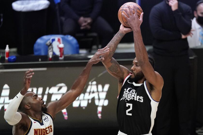 Los Angeles Clippers forward Kawhi Leonard, right, shoots as Denver Nuggets forward Paul Millsap.