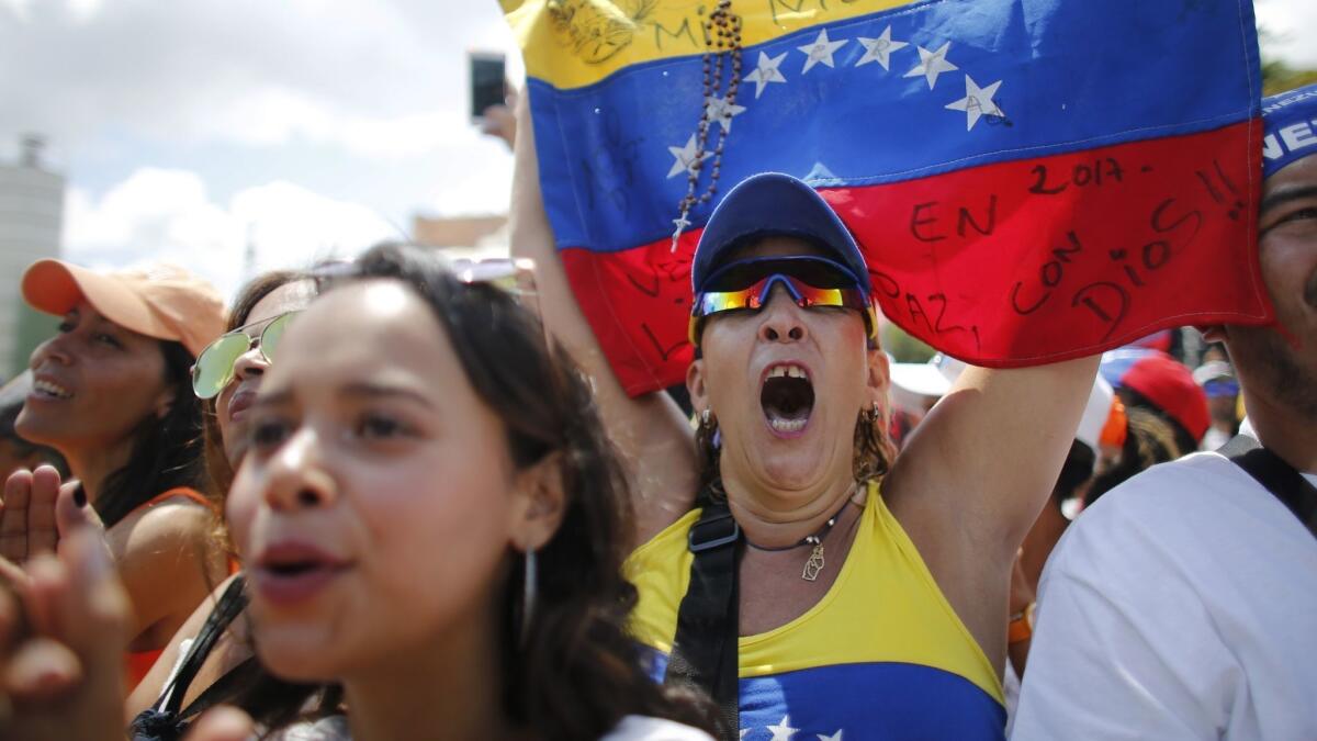 Anti-government protesters in Caracas on Monday cheer during a rally demanding the resignation of Venezuelan President Nicolas Maduro.