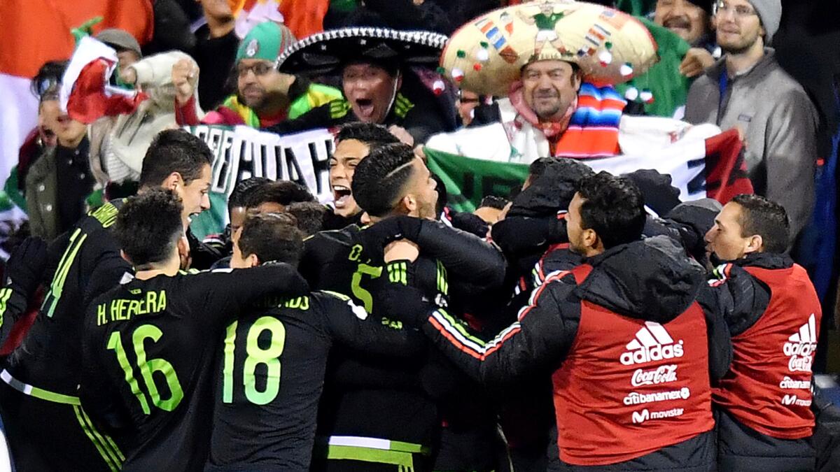 Mexico's Miguel Layun (center) is swarmed by teammates after scoring against the U.S. in a World Cup qualifier on Friday night.