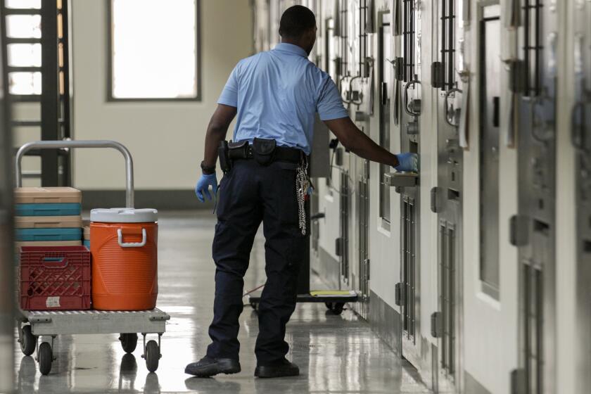 ADELANTO CA AUGUST 31, 2017 --- A guard distributes lunch at Adelanto Detention Facility West. Prison facility have long been accused by detainees of medical neglect, poor treatment by guards, lack of response to complaints and other problems.(Irfan Khan / Los Angeles Times)