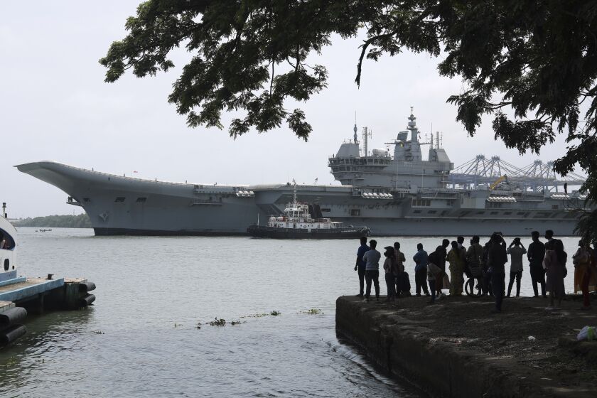 People watch the INS Vikrant leave for trials in the Arabian Sea in Kochi, India, July 2, 2022. India is preparing to relaunch INS Vikramaditya aircraft carrier after a major refit, a critical step toward fulfilling its plan to deploy two carrier battle groups as it seeks to strengthen its regional maritime power to counter China's increasing assertiveness. (AP Photo/Melton Antony)