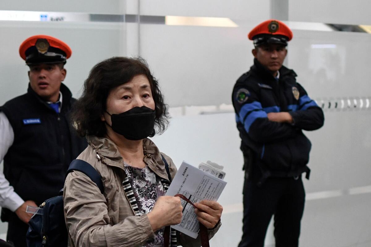Woman wears a protective mask at Mexico City International Airport
