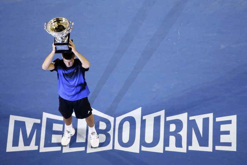 FILE - Serbia's Novak Djokovic holds a trophy after beating Jo-Wilfried Tsonga, of France, in the final of the Men's singles at the Australian Open tennis tournament in Melbourne, Australia, Sunday, Jan. 27, 2008. Djokovic will be trying to set the record for the most Grand Slam singles trophies won by a man when he goes for what would be No. 23 against Casper Ruud in the French Open final on Sunday, June 11, 2023. Djokovic enters that match with 22, tied with his rival Rafael Nadal. Roger Federer, who announced his retirement last year, is next with 20. (AP Photo/Mark Baker, File)