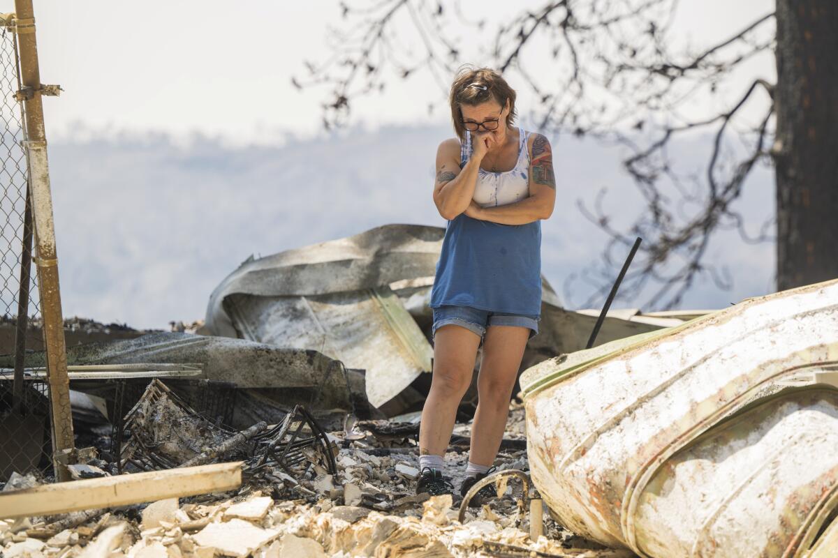 A woman is found surrounded by rubble with her head in her hands.