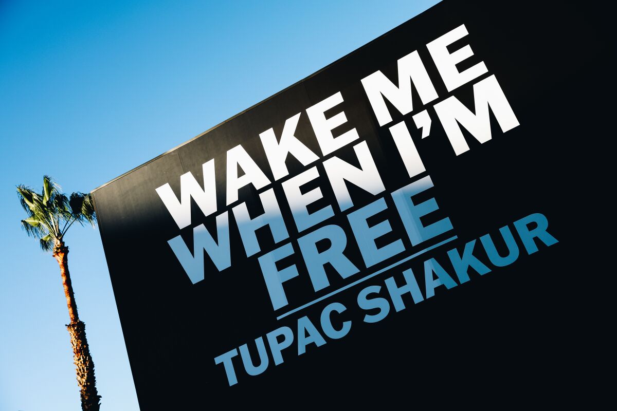  "Wake Me When I'm Free | Tupac Shakur" written in giant white letters on the side of a black building