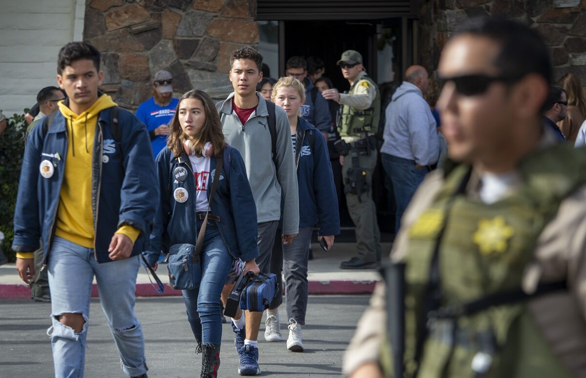 Students walk to a reunification area after a gunman opened fire on their campus.