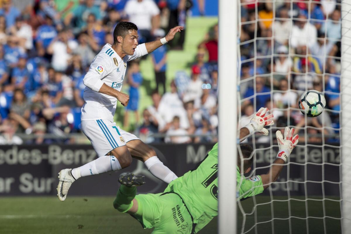El astro del Real Madrid, Cristiano Ronaldo (i), dispara, pero el balón sale a un lado de la portería del Getafe.