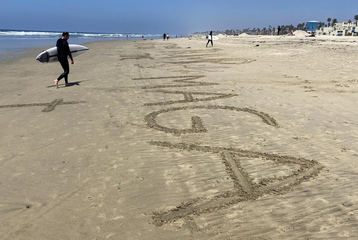 Someone wrote "MAGA" on the sand at Huntington City Beach during protests on May 1, 2020.