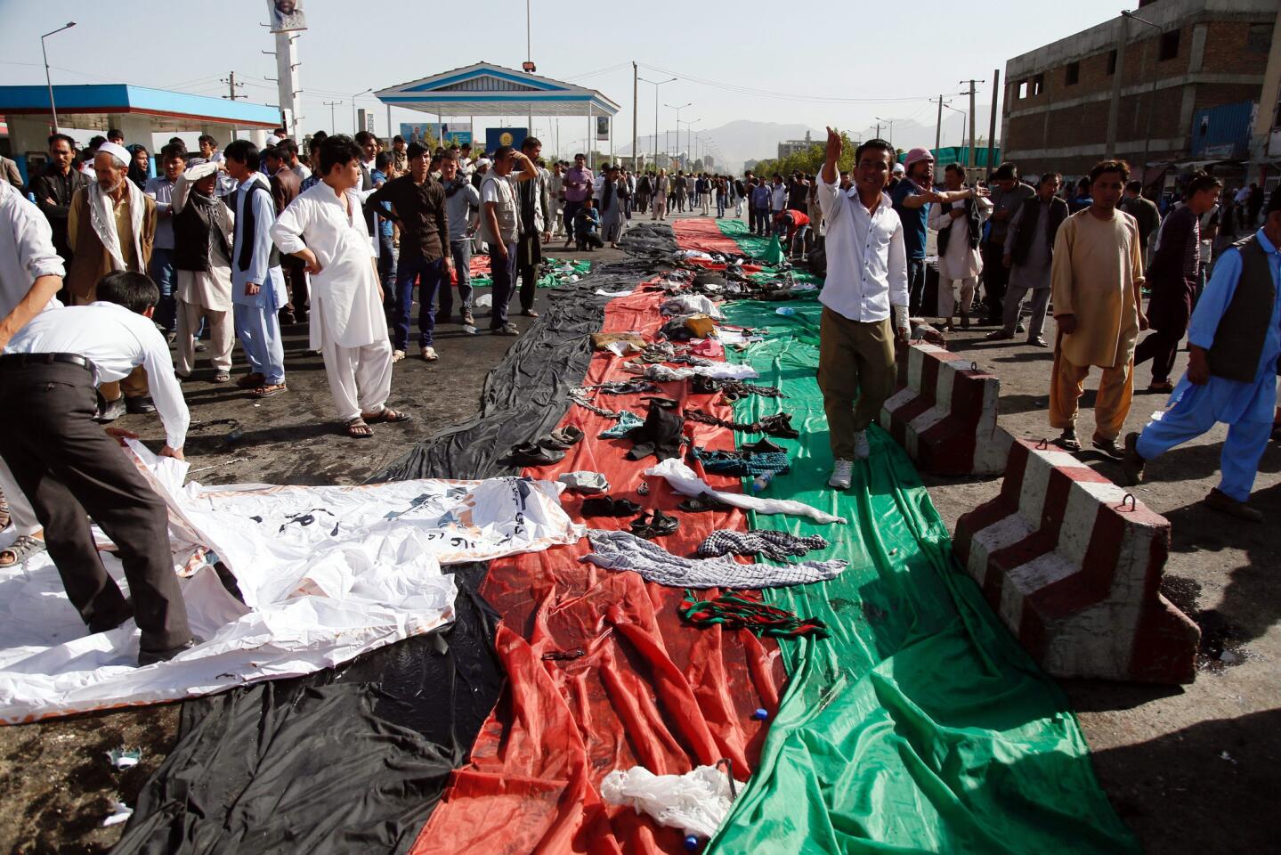 People collect the belongings of the victims at the scene of suicide bomb attack that targeted a demonstration of Hazara minority in Kabul, Afghanistan on July 23, 2016. People from Hazara minority were protesting the proposed route of the Turkmenistan, Uzbekistan, Tajikistan, Afghanistan, and Pakistan (TUTAP) power line, calling on the government to re-route the line through Bamiyan province which has a majority of Hazara population.