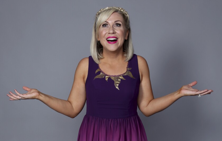 Ashley Eckstein poses for a portrait in a purple dress in 2018.