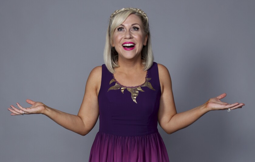 Ashley Eckstein pose pour un portrait dans une robe violette en 2018.