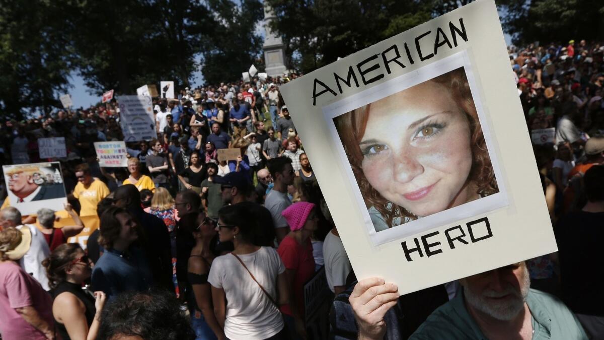 A counter-protester holds a photo of Heather Heyer at a "Free Speech" rally organized by conservative activists in Boston on Aug. 19, 2017.