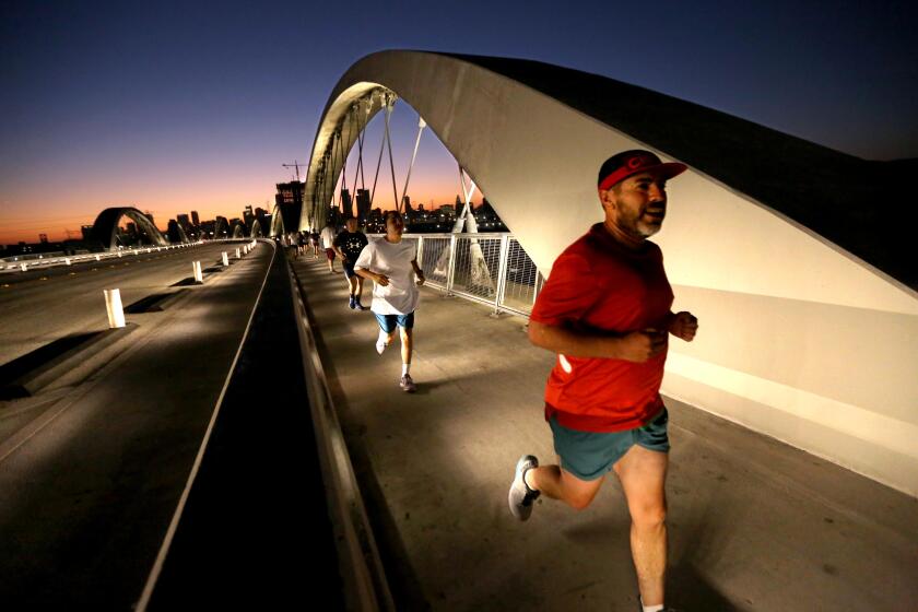 The Boyle Heights Bridge Runners make their way across the Sixth Street Viaduct in Los Angeles on August 2, 2023.