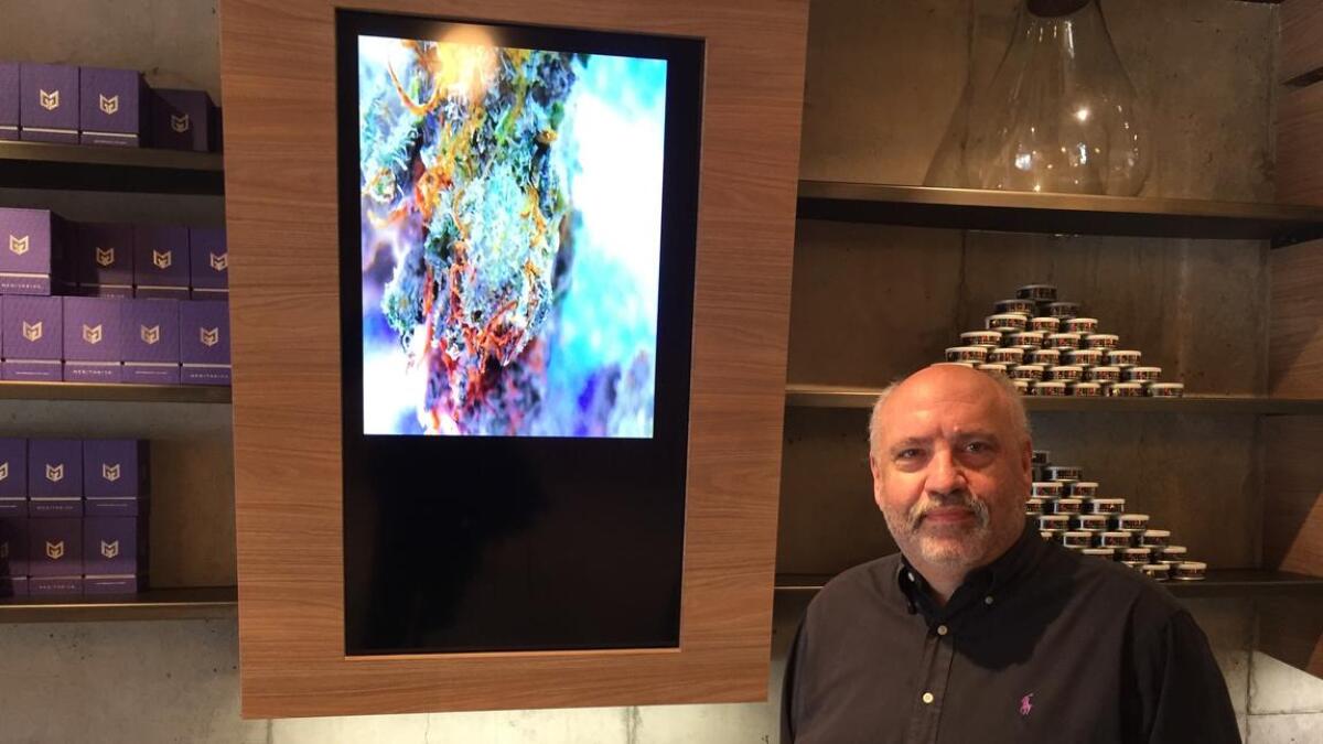 Medithrive dispensary owner Jeff Linden with one of the high-powered microscopes customers can use to inspect their purchases. The magnified images appear on large, wall-mounted screens.
