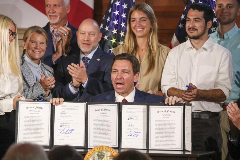 Florida Gov. Ron DeSantis signs legislation on Monday, May 15, 2023, banning state funding for diversity, equity, and inclusion programs at Florida's public universities, at New College of Florida in Sarasota, Fla. (Douglas R. Clifford/Tampa Bay Times via AP)