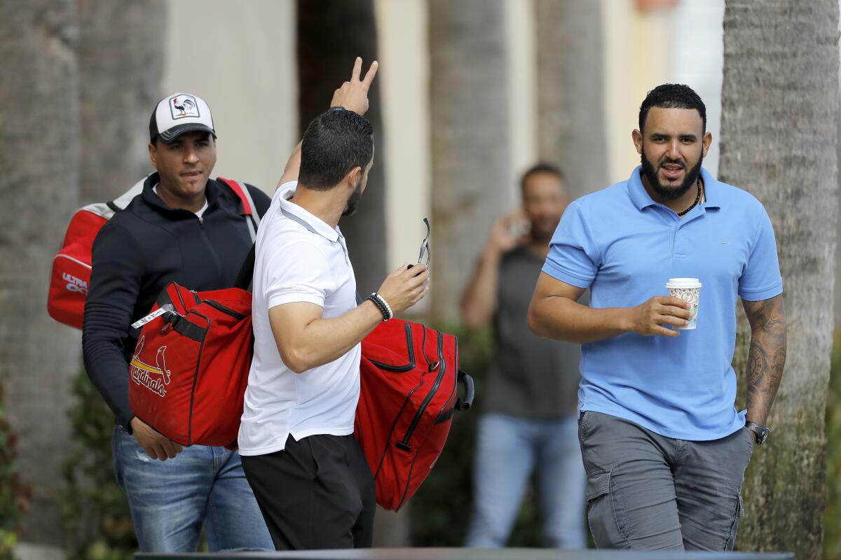 St. Louis Cardinals minor league players leave the team's spring training baseball facility in Jupiter, Fla., on March 13.