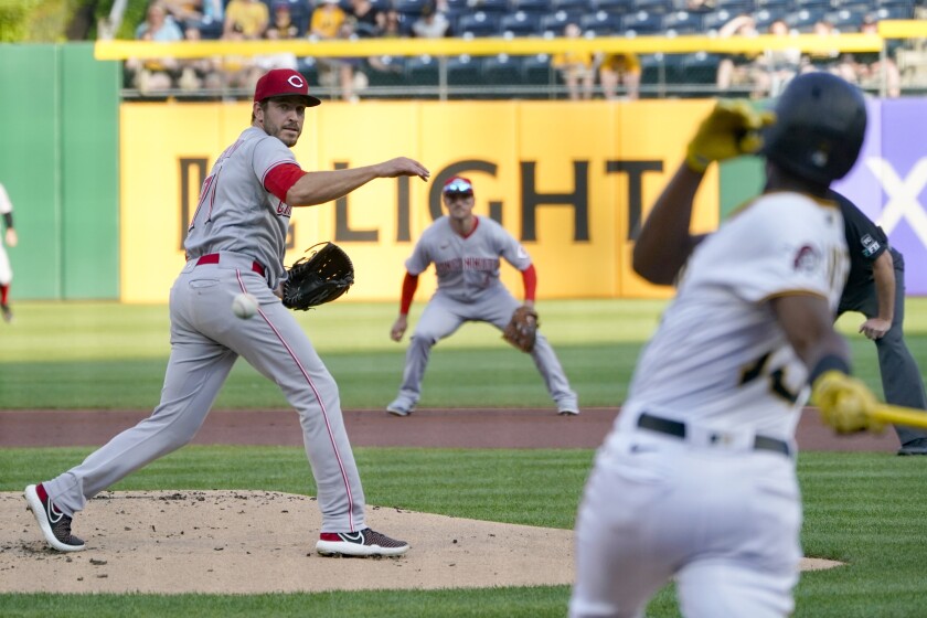 Pittsburgh Pirates' Ke'Bryan Hayes, right, hits an infield ground ball past Cincinnati Reds starting pitcher Connor Overton during the first inning of a baseball game Thursday, May 12, 2022, in Pittsburgh. Hayes reached first as Ben Gamel was forced out at second. (AP Photo/Keith Srakocic)