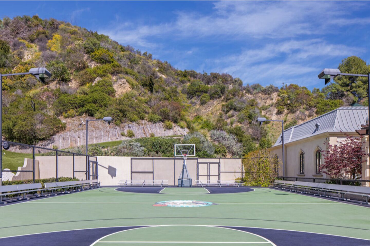The basketball court with a hill in the background.